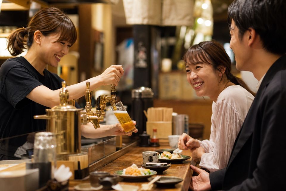店員がお酒を注ぐ接客シーン