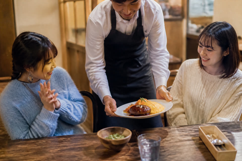 料理を提供するスタッフとお客様